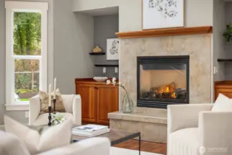 Gas fireplace with tile surround, built-in cabinetry, and warm natural finishes create an inviting focal point in the living space.
