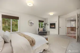 Serene primary retreat with fireplace, generous proportions, and space for a private sitting area.