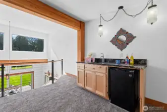 wet bar with mini fridge and sink in upper loft