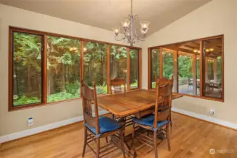 This cozy kitchen dining room features expansive windows framing picturesque views.