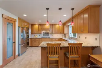 kitchen with granite counters, double oven, 5-burner stove & bar seating