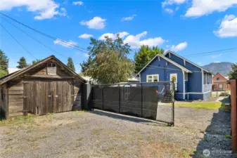 Back yard with garage and gate partially open