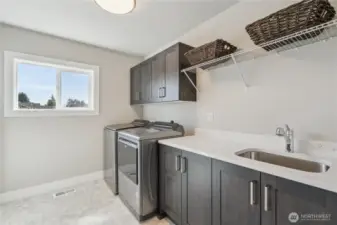 Upper level Laundry room with sink and spacious linen closet