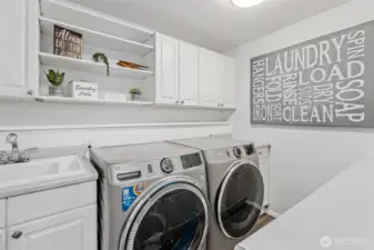 Lower level laundry w/ sink, counter & plenty of cabinetry