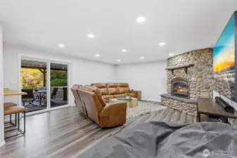 Lower level living room w/ river rocked fireplace