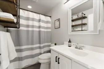 Main floor full bathroom with tub and shower enclosure.
