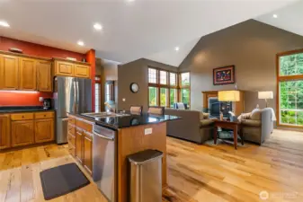 The Hickory wood floors is a real stand out in this photo taken from the dining area. The wall of windows in the distance really captures how much natural light comes into the living space!