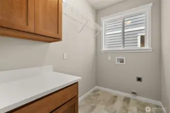 Separate laundry room with cabinets and a high hanging shelf for extended storage.