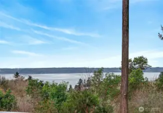 View of Puget Sound and Vashon Island over Salmon Creek Reserve. Sunsets behind the Olympic Mtns.