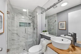 Stylish updated bath with sleek vessel sink, modern fixtures & glass-enclosed shower. Crisp tilework & contemporary finishes create a clean, spa-inspired feel.