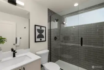 The tile-lined guest bathroom sports a walk-in shower with built-in and clerestory window for added natural light!