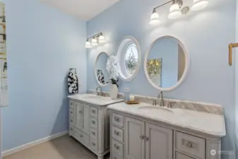 Primary suite bathroom elegance abounds with these stately vanities, topped with marble and a pretty round accent window with leaded glass design for added privacy. Plus a tankless water heater means endless hot water!