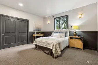 The floorplan provides a split bedroom plan, with this 2nd bedroom, the 3rd bedroom and den on one side of the home, and the primary suite on the other side of the home. Wainscot continues in the bedroom along with the accent sconce lighting.