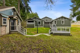 From this vantage you can see the seamless connections from the Trex deck courtyard style space between the home and the pool house, then how it leads down to another deck and to the walkway for the pub house. Note the charming light post to keep everything well lit at night.