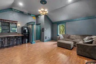 An amazing gathering space outbuilding “pub” at the end of the backyard deck walkway is detached from the home and comes with a pub-style bar counter and a wall begging for your big screen TV! Wood laminate flooring, pillar accent, chandelier & medallion and wood wrapped windows too.