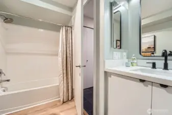 full size tub with shower and tile surround