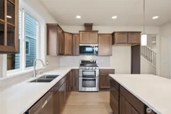 Cocoa-stained maple cabinets and quartz countertops throughout home. Double ovens are included too!