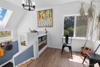 Sitting area by main floor stairs to back entry & basement. This could be storage, reading nook, breakfast nook, home office?