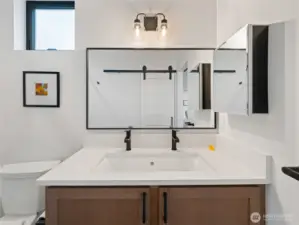 Owner's suite bathroom with storage cabinet and closet.