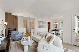 The spacious living room sports vaulted ceilings, vinyl plank flooring and a cozy gas burning fireplace with fluted wood statement wall.