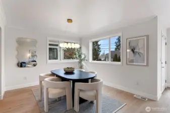 The dining room features new luxury vinyl plank flooring, a stunning chandelier and windows on 2 sides for maximum natural light.
