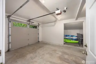 Attached single car garage with storage on the side.