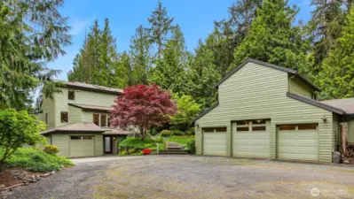 Detached 4 car garage has an upper level workshop with 1/2 bath