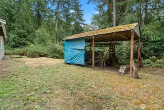 Carport that is currently used as a wood shed.