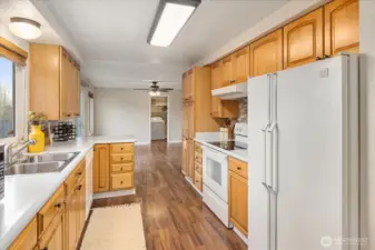 A galley-like kitchen flows from dining room into the a second living space.