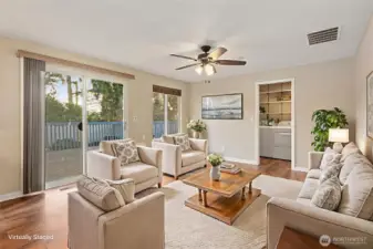Second living space, featuring updated ceiling fan and lighting fixture. Sliding door leads out to large deck and fully fenced backyard.
