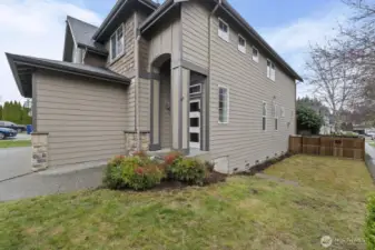 Front corner of home including a large side yard!