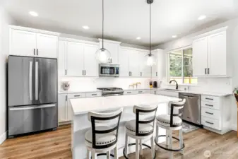 Hello, kitchen! Bright and sparkling with under-cabinet lighting, pull-out drawers, a pantry, and a spacious island with an eating bar—perfect for cooking, entertaining, and everyday family life.
