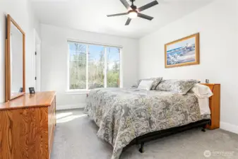 The primary bedroom features a walk-in closet, serene views of the greenspace, and direct access to the spacious attached primary bathroom.