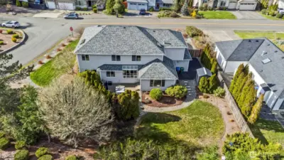 Backyard with partial fencing, trees and shrubs for privacy.