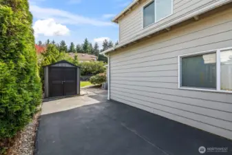 Extra parking on side of home with an outdoor shed for your landscaping tools.