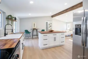 A picturesque view from the kitchen into the open living areas, showcasing a stylish island with abundant extra storage.