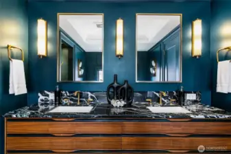 The En Suite Bath/Dressing Room continues its refined palette with twin vanities in warm walnut, veined Nero Marquina marble, and antique brass fixtures. Framed mirrors and fluted sconces echo the Art Deco vernacular—luxury with lineage, elevated for modern living.