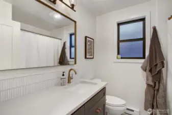 Full bathroom with tub, shower, and nice storage.
