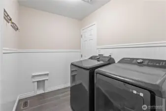 Utility room features beadboarding and new flooring