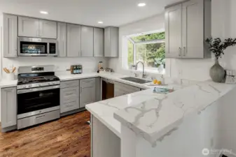 The newly remodeled kitchen boasts quartz countertops, shaker cabinetry, new stainless steel appliances.