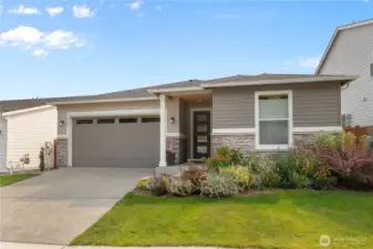 Inviting Curb Appeal – Modern single-level home with stone-accented façade, covered entry, and low-maintenance landscaping for easy year-round care.