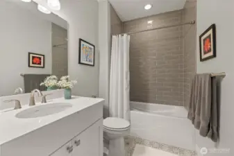 Stylish Guest Bath – Crisp and modern with updated tile surround, elegant quartz vanity, and contemporary fixtures. Perfectly located for guests or daily use.