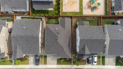 Bird’s-Eye View of 6685 Skipper Ln SE – Overhead view highlighting the home (center) with fully fenced backyard and proximity to the community playground.