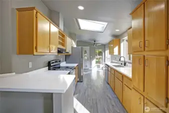 Updated Kitchen with Slab Quartz Counters and Farmhouse Sink.