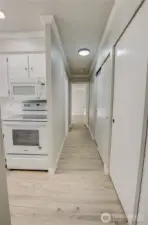 Hallway front on view from living room. Kitchen opening to the left.