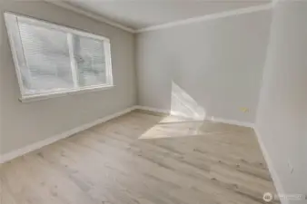 Bedroom with large window bringing in plenty of natural light. New paint and LVP floors for a refreshed space.