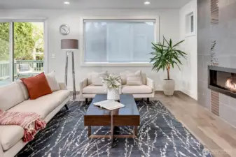 The expansive great room showcases sleek hardwood floors and a wall-mounted fireplace.