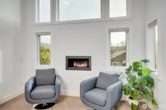 A cozy sitting area with fireplace, and large windows that bring in abundant natural light.