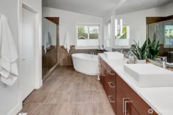 The spa-like bathroom features a standalone soaking tub, generous walk-in shower, & skylight.