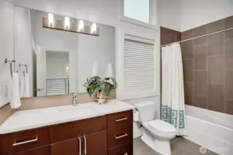 A guest bath with high ceilings and a large panaled window.